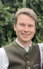 junger Mann in Trachtenweste, lächelt